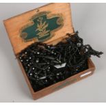 A wooden cigar box containing assorted French jet beads.
