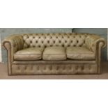 An olive green leather Chesterfield settee.