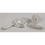 Three silver items, a silver backed hand mirror and two cut glass dressing table jars.