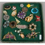 A tray of vintage costume jewellery brooches.