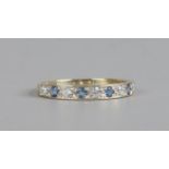 A 9ct gold half eternity ring set with sapphires and white paste stones, size M1/2.