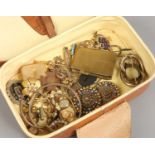 A tan pig skin leather vanity case and contents of yellow metal costume jewellery,