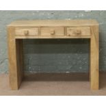 A hardwood three drawer side table.