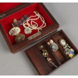 A carved wooden jewellery box and contents of costume jewellery including cufflinks, brooches,