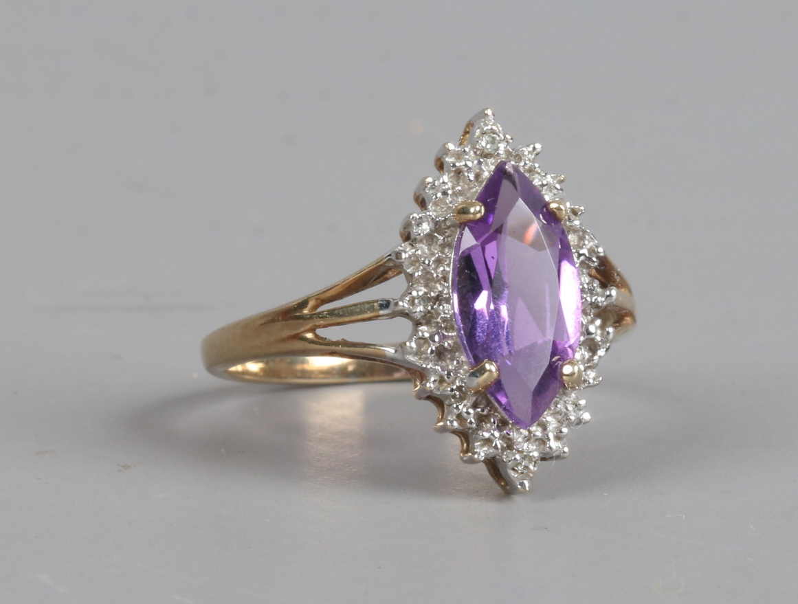 A 9ct gold ring set with marquise cut amethyst and diamonds, size O.