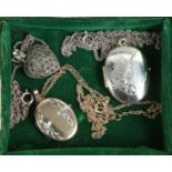 Two silver lockets on chains and a silver and marcasite locket on chain.