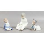 Three Nao figures modelled as children including a pair each with a supper dish.