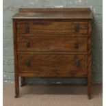 An oak chest of three drawers raised on square cut castered legs.