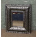 A bevel edge wall mirror in painted silver gilded cushion frame.