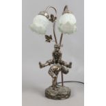 A silvered figural twin branch tablelamp modelled as a pair of boys playing leap frog.