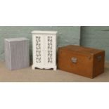 A plywood storage chest along with a painted cupboard and a Lloyd loom linen basket.