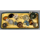 A tray of vintage costume jewellery brooches.