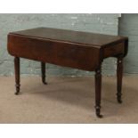 A Victorian mahogany Pembroke table raised on turned castered leg with cutlery drawer.