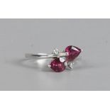A 9ct white gold pink tourmaline and diamond ring in a cross over setting with pear cut stones,