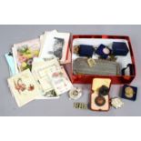 A box of various miscellaneous to include postcards, military badges,
