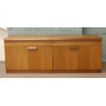 A teak sideboard with bi-fold cupboard doors.