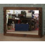 An oak rectangular framed mirror with floral effect iron work decoration.