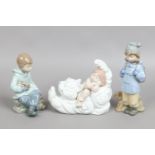 Three Nao figures modelled as children two in winter dress with animals.