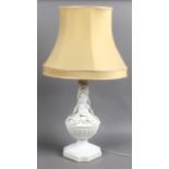 A 1960s/70s white glazed pottery tablelamp, moulded with flowers with fabric shade.