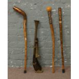 Three carved and decorated walking sticks along with ornamental blunderbuss.