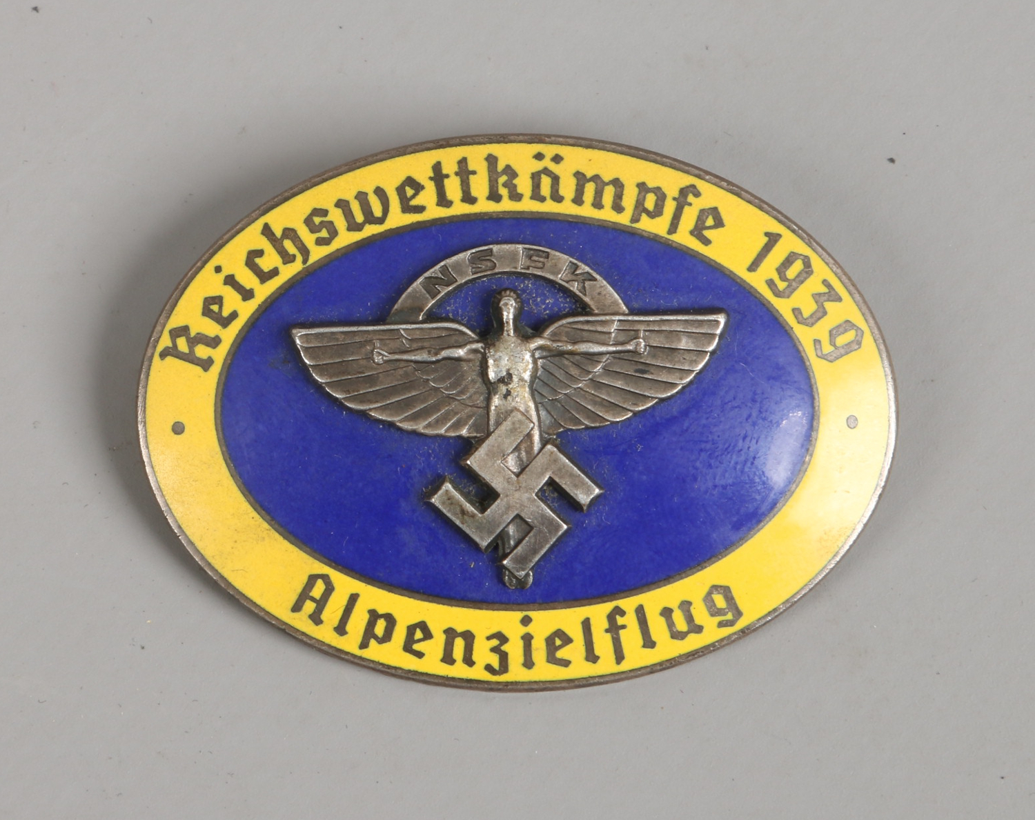 A World War II German Third Reich NSFK oval enamel badge, makers stamp for Ges Gesch.