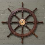 A turned hardwood ships wheel with brass central boss.