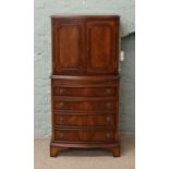 A mahogany bow fronted cocktail cabinet with internal mirrored back incorporating both cupboard and