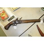 A reproduction flintlock pistol having mahogany body