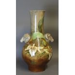A Victorian pottery vase, with twin rams head handles, decorated with all over flowers and leaves