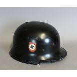 A WWII German ebonised metal helmet, bearing 'Nazi' decals, 29cm x 23cm x 16cm high, some wear