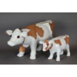 Two white glazed pottery cows by Steve Beverly Hills American Craft, 34cm and 21cm high