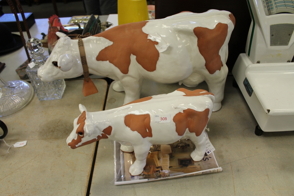 Two white glazed pottery cows by Steve Beverly Hills American Craft, 34cm and 21cm high