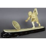 A Japanese carved ivory figure of a man, chasing after his hat in the wind, 32cm long x 15cm high,