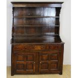 An early 18th Century panelled oak dresser, with open rack, the base enclosed by a pair of fielded