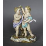 A late 19th/early 20th Century Meissen porcelain figure of two putti with cornucopia of flowers,