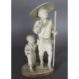 A superb early 20th Century Japanese naturalistically carved ivory figure of a father and son, on