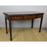 A George III mahogany serpentine fronted serving table, with fluted frieze and ovolo mounts,