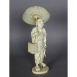 An early 20th Century Japanese carved ivory figure of an elderly man holding a parasol, 27cm high,