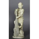 An early 20th Century Japanese carved ivory figure of a fisherman hauling net, 23cm high, signed