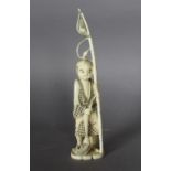 An early 20th Century Japanese carved ivory figure of a boy with a fishing pole, 19cm high, in