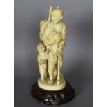 A Japanese carved ivory figure of a woodsman holding a rabbit, his son with outstretched arms,