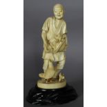 A Japanese carved ivory figure of a man feeding chickens, 19cm high, carved signature to base, Meiji