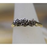 An 18ct gold three stone illusion set diamond ring, ring size L