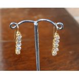 A pair of handmade gold coloured metal (assumed high carat) and diamond set earrings (for pierced