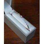 A 9ct white gold and white stone set bangle of wave design Good condition