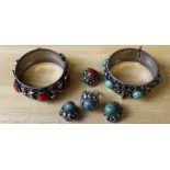 Two white metal bangles, with red and green cabochons, three similar earrings and a ring 60.