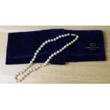 A single strand pearl necklace with white metal clasp marked 'Sil' and M within a sheild, 38cm long,