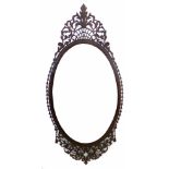 Mahogany pierced wall mirror, the oval landscape oriented glass surrounded by an elaborately pierced