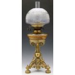 Cast brass table oil lamp and shade, the cut glass reservoir and brass frame in the form of a