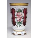 Bohemian overlay glass beaker, the cranberry and white glass body cut through and enamelled with